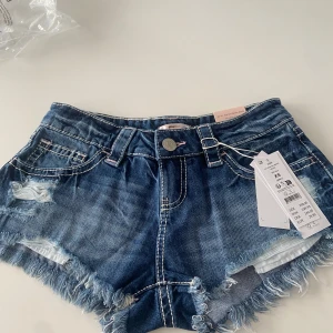 Slutsålda shorts från Gina tricot 14+ - Säljer helt nya slutsålda jeanshorts från Gina tricot 14+. Shortsen är lågmidjade och har en sliten effekt, jag säljer dem pågrund av att de inte passade då jag tror att de är större i storleken.