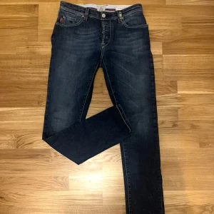 Tramarossa Jeans - Snygga mörkblå jeans från Tramarossa. Modellen heter leonardo vilket motsvarar slim fit. Säljer dem pga att de inte passade. Nypris runt 4000. Priset är ej hugget i sten. Ytterben: 108 innerben: 81 midja: 86