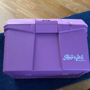 Lila ryktväska från Börjes - Stor och rymlig lila ryktväska från Börjes med praktiskt handtag och robust plastmaterial. Perfekt för att organisera borstar och tillbehör till stallet. Väskan har ett innerfack och gott om plats för allt du behöver till hästen. Den är helt oanvänd och alla tillbehör med. Frakt ingår inte i priset men dock kan pris diskuteras för varan.
