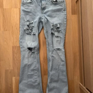 Ljusblå slitna bootcut jeans - Ljusblå bootcut jeans med egengjorda hål. 