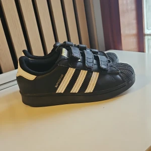 Superr fina💞💞 svarta addidas sneakers. - Klassiska svarta Adidas Superstar med vita ränder och som har kardborrband. Fraktkostnaden beror på adressen💞💞