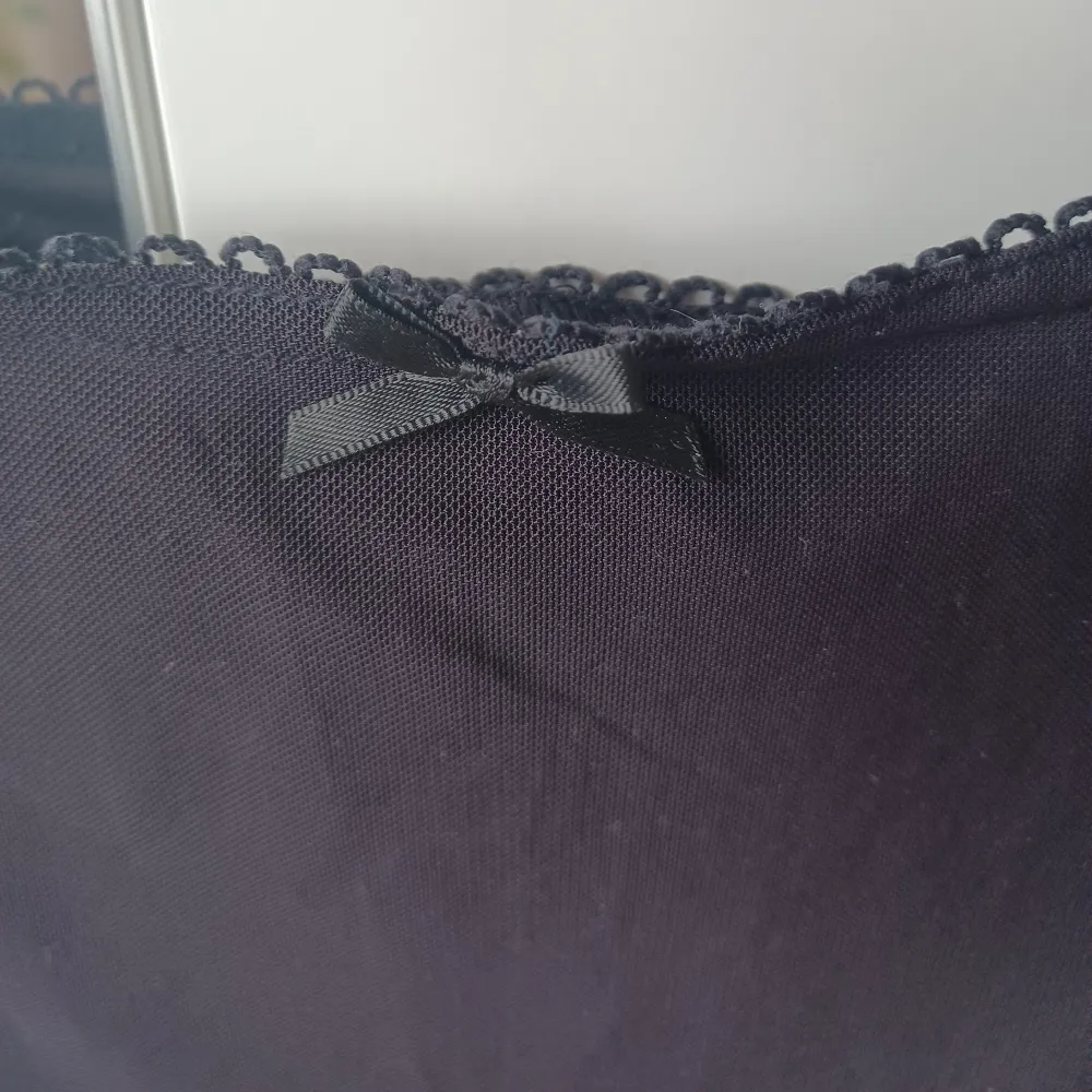 Säljer en svart meshkjol med söt liten rosett framtill och spetsdetaljer längs nederkanten. Kjolen har en underkjol av lite 'tjockare' tyg och ett meshliknande tyg ovanpå! 💕. Hameet.