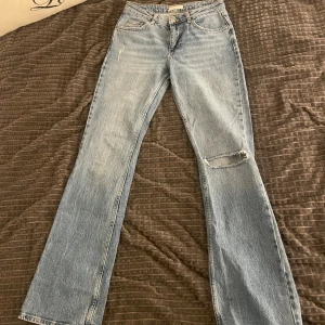 Ljusblå jeans med slitning från Gina tricot  - Ljusblå jeans med raka ben och slitning vid knät från Perfect Jeans. Klassisk femficksmodell med normal passform och hög midja. Perfekta för en avslappnad stil.