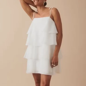 Vit volangklänning med smala axelband - Superfin vit klänning med flera lager volanger och smala knytbara axelband. Perfekt till studenten eller bara till sommaren💕använd endast en gång, så jättebra skick!!