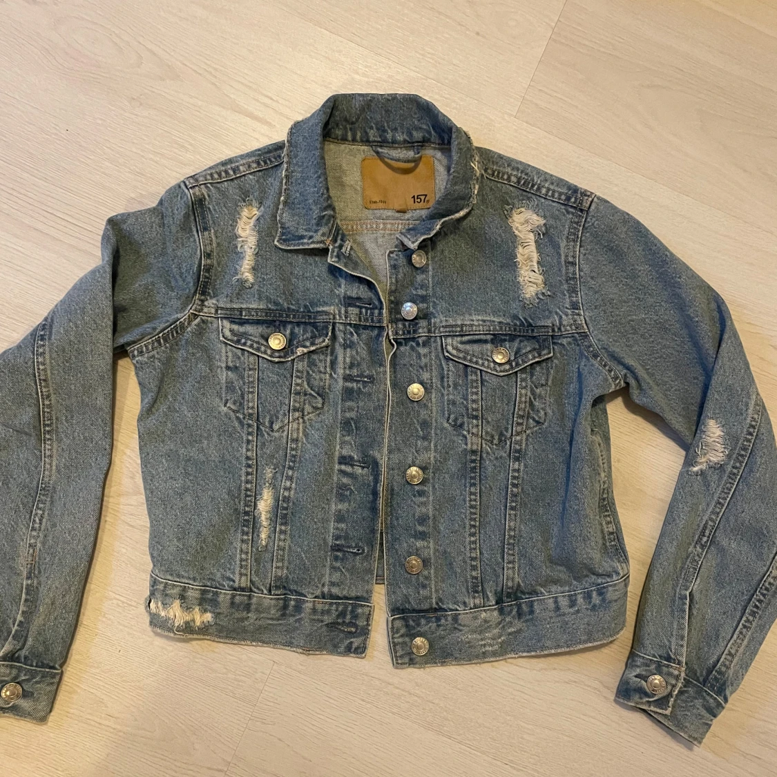 Blå jeansjacka med slitningar från 157