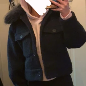 Meotine liknande  - Säljer en mörkblå teddyjacka med stor pälskrage. Jackan är croppad och har stora fickor framtill samt knappar. Perfekt för dig som vill ha en mysig och trendig jacka till vardags. Passar mig som vanligtvis har xs, använd endast 1 gång typ.
