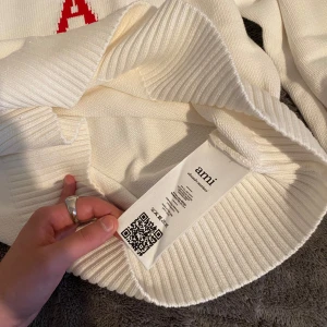 Vit stickad tröja från Ami Paris  - Säljer en stilren vit stickad tröja från Ami, använde den 2 ggr