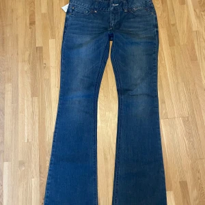 Blå bootcut jeans från Bondelid - Snygga blå bootcut jeans från Bondelid med klassisk femficksdesign och subtila slitningar. Jeansen har hög midja och ett litet RL-emblem på bakfickan. Perfekta för dig som gillar en tidlös och avslappnad stil. Helt nya❤️ 