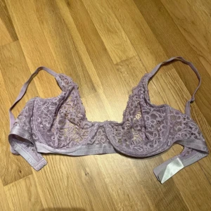 Ljuslila spets-bh från Lounge Underwear - Säljer en superfin ljuslila bh från Lounge Underwear i spets med transparenta partier och tunna axelband. Perfekt för dig som gillar romantiska detaljer och snygg design.