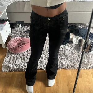 Svarta bootcut jeans från Perfect Jeans - Säljer ett par svarta jeans från Perfect Jeans i modellen bootcut. Byxorna har normal passform och klassisk femficksdesign med knapp och dragkedja framtill. Perfekta till dig som gillar en tidlös look med lite utsvängda ben.