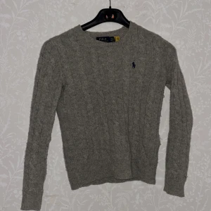 Grå stickad tröja från Polo Ralph Lauren - Säljer en klassisk grå stickad tröja från Polo Ralph Lauren . Säljer den för den passar inte min stil, den är helt ny har använt den max 5 gånger.  Ord pris:  2.395:- men säljer för 1000kr