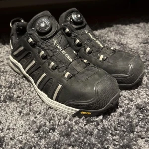 Svarta X-Solid Gear sneakers med BOA-snörning - Svarta sneakers från Solid Gear med BOA-snörning och robust Vibram-sula. Skorna har detaljer i grått och vitt samt förstärkt tåparti. Perfekta för dig som vill ha slitstarka och bekväma skor till vardags eller träning.