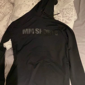 Svart hoodie från MM Sports - Tja säljer denna helt nya mm sports gym hoodien, aldrig använd skick 10/10 säljer pga inte passar mig,inga defekter eller skador alls har bara hängt på en galje! som sagt helt nya, nypris 399 hör av er pris kan diskuteras! 
