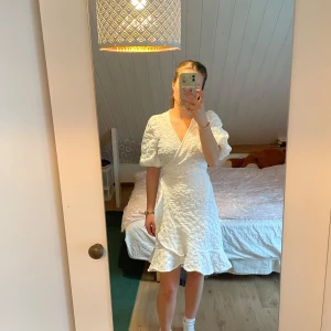 Vit omlottklänning  - Superfin vit klänning från Vero moda med omlottmodell och volangdetaljer. Använd 2 gånger, så gott som ny. Skriv för frågor eller fler bilder💕