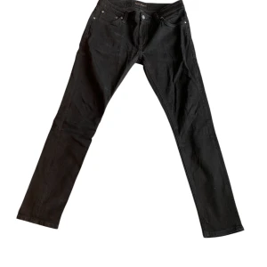 Nudie jeans svarta - Ett par riktigt feta nudie jeans i svart med skick i 9/10 dessa jeans är perfekta för flera outfits o h sitter underbart i passformen. Priset kan duskuteras vid snabb och smidig affär! 
