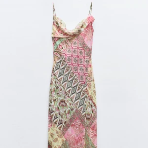 Mönstrad långklänning med tunna band - Säljer en superfin långklänning med tunna axelband och draperad urringning. Klänningen har ett färgstarkt patchworkmönster i rosa, grönt, beige och vitt. Materialet är lätt och flowy, perfekt för varma dagar. Slits nertill för extra vibe. Använd en gång, så skick är som ny. Storlek XS men passar även en S. Pris kan diskuteras vid snabb affär🌸