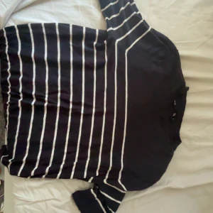 Svartvit randig tröja från lager 157 - Svart tröja med vita horisontella ränder från lager 157. Tröjan har rund halsringning och trekvartsärm, vilket ger en avslappnad och trendig look. Perfekt för dig som gillar enkel men snygg stil. Tröjan är i superbra skick, bara använt 2 ggr tidigare. 