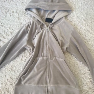 Vintage Juicy Couture beige kofta 🤍 Storlek XS - Supermjuk beige velour hoodie från Juicy Couture med dragkedja, huva och snörning. Klassisk JC-logga broderad på bröstet och fickor framtill. Perfekt för en chill och trendig look. 