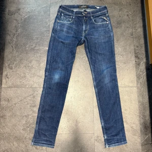 Replay Anbass blå jeans herr - Snygga blå jeans från Replay, modell Anbass. Klassisk femficksdesign med smal passform och raka ben. Jeansen har tydliga kontrastsömmar och är tillverkade i bomull med en liten del elastan för extra komfort.