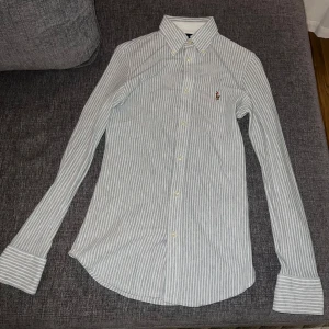 Ralph Lauren skjorta nyskick - Ralph Lauren skjorta i slim fit storlek XS för kvinnor. Den randiga vit/gråa skjortan är en present som endast testats men aldrig använts. Nypris: 1199kr