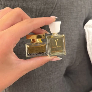 YSL & Dolce Gabbana miniparfymer - Två exklusiva miniparfymer: YSL Eau de Toilette i en fyrkantig glasflaska med vit kork och guldtext samt Dolce & Gabbana The One i en kompakt glasflaska med lyxig guldfärgad kork. Dolce Gabbana parfymen innehåller 5ml och YSL 7,5💓