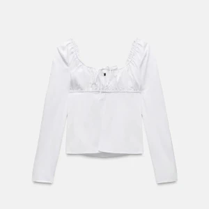 Vit blus med knyt från Zara XS - Supersöt vit blus från Zara i storlek XS. Den har långa ärmar, fyrkantig urringning och fina rynkade detaljer upptill med knytband framtill. Blusen är lätt utsvängd nertill och gjord i bomull för en fräsch och luftig känsla.