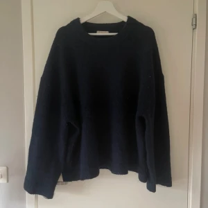 Mörkblå stickad tröja Gina Tricot L - Mysig mörkblå stickad tröja från Gina Tricot i storlek L. Tröjan har en loose passform, rund halsringning och långa ärmar. Perfekt för kyliga dagar och enkel att styla med jeans eller kjol. Sitter mer som en M.