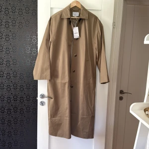 Beige trenchcoat från Claire Rose NAKD  - Stilren beige trenchcoat från Claire Rose x NAKD, prislapp kvar aldrig använd. Nypris 1103kr
