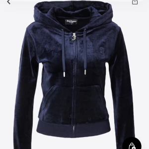 Juicy couture hoodie - Säljer en klassisk svart hoodie i mjuk velour från Juicy Couture. Tröjan har dragkedja framtill, huva med snören och ribbade muddar. Perfekt för en avslappnad och trendig look.