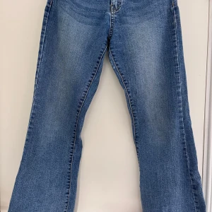 Blå bootcut jeans med medelhög midja - Blå bootcut jeans med medelhög midja från gekås. Jeansen är lite större i storleken och är även lite stretchiga. Inte använda mycket alls så är i fint skick.