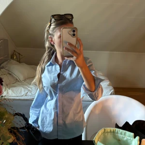 Ljusblå klassisk skjorta - Säljer en ljusblå skjorta med klassisk krage och långa ärmar. Skjortan har är figursydd men lite stor på mig 