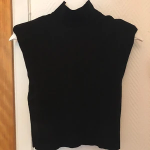 Svart topp från Zara - Säljer en svart topp från Zara. Den är croppad och har axelvaddar, vilket ger en väldigt smickrande passform. 
