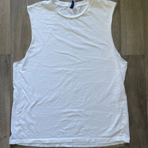 H&M vit ärmlös t-shirt Divided - Vit basic t-shirt från H&M Divided i storlek XL. Längden är 73 cm. Skönt att ha på sig denna på sommaren