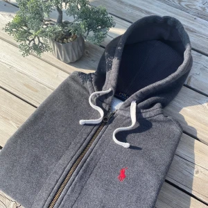 Grå zip hoodie från Ralph Lauren - Tjena! Säljer en mörkgrå zip hoodie från Polo Ralph Lauren i storlek XS. Det är riktigt bra skick och passar dig som är runt 170 till 175 cm. Vid frågor är det bara att skriva!🥂 priset inte hugget i sten