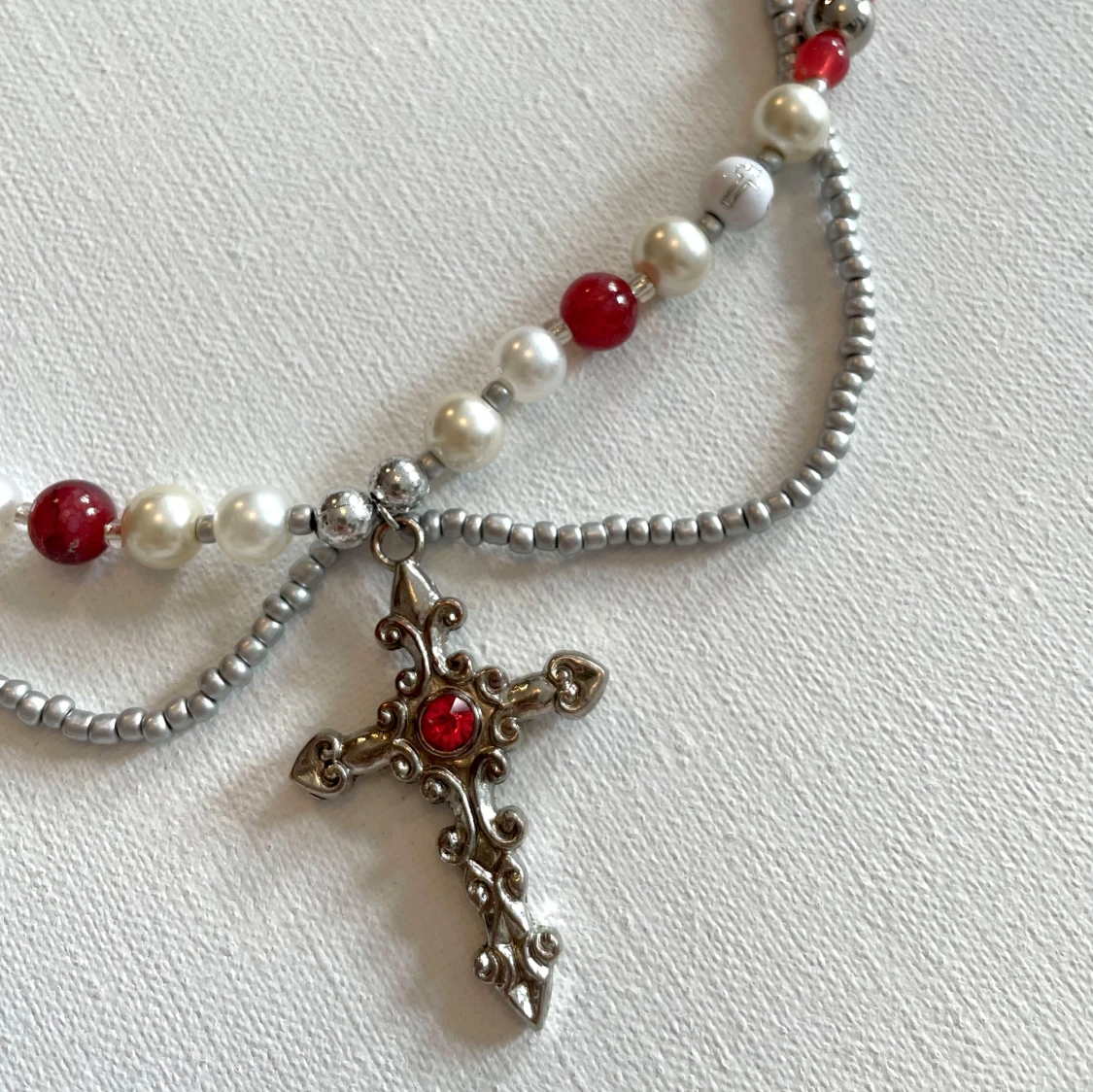 Pärlhalsband med kors och röda detaljer