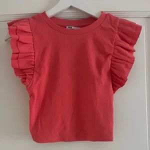 Rosa volangtopp från Zara - Superfin rosa topp från Zara med breda volangärmad. Toppen är ribbad. Använd 2 gånger så i väldigt bra skick. Passar både xxs, xs och s