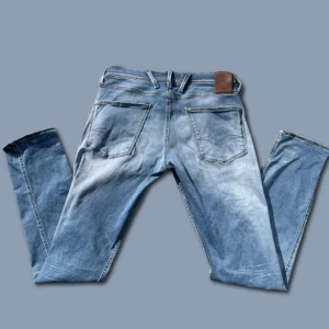 Replay anbass - Snygga blå jeans från Replay, modell Anbass. De har en klassisk femficksdesign med knappgylf och dragkedja. Perfekta för en avslappnad stil. Hör av er vid frågor!