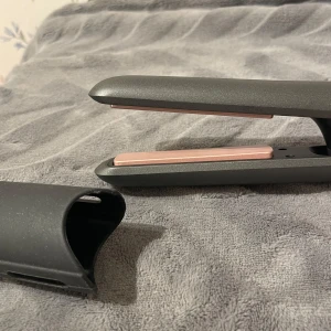 Svart trådlös plattång  - Liten trådlös plattång som är bra att ha med sig i väskan! Justerbar värme mellan 160-200°C. Kommer med värmeskyddande fodral och ett svart skyddshölje. Perfekt för att styla håret snabbt och enkelt. Ladda med en vanlig laddare, återkommer med vilken ladd typ.