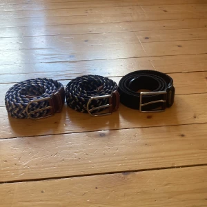 Tre flätade bälten i olika färger (ALLA 3 FÖR 350kr!) - (ALLA 3 FÖR 350kr!)Säljer tre snygga flätade bälten med metallspänne. Ett helsvart bälte med svart spänne, ett blått och vitt bälte med brunt läder vid spännet, samt ett mörkblått och grått bälte med brunt läder. Perfekta accessoarer för att lyfta din outfit.