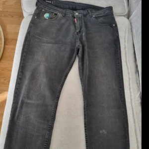 Svarta jeans från Dsquared2 - Snygga svarta jeans från Dsquared2 med klassisk femficksdesign och coolt Dsquared2-märke på fickan. Jeansen har en rak passform och är tillverkade i mjukt denimtyg. Perfekta för dig som gillar streetstyle och vill sticka ut lite extra.