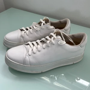 Vagabond skinn sneakers ”John”  - Stilrena vita sneakers med rund tå och platt sula. Skorna har snörning och är tillverkade i mjukt skinn för en clean och tidlös look.