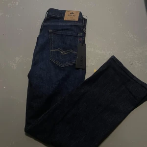 Mörkblå Replay jeansbyxor - Snygga mörkblå jeans från Replay. Jeansen har en stilren look med diskret logga på bakfickan och läderpatch i midjan. Perfekta för dig som gillar en tidlös och clean klädstil även kallad grisch. Ett riktigt kap, köp nu!