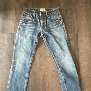 Ljusblå jeansbyxor från Crocker - Snygga ljusblå jeansbyxor från Crocker med klassisk femficksdesign och slitna detaljer. Jeansen har raka ben, normal passform och är tillverkade i bomull. Perfekta för en avslappnad och trendig look.