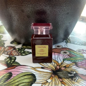 Tom Ford Lost Cherry parfym 7,5 ml - Tom Ford Lost Cherry Eau de Parfum i en lyxig mörkröd glasflaska med rosa transparent kork. Flaskan rymmer 7,5 ml och har en elegant guldig etikett framtill. Doften är känd för sina söta och fruktiga körsbärstoner.