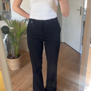 Svarta kostymbyxor - Snygga svarta kostymbyxor med hög midja och bootcut-stil. Perfekta för en stilren look.