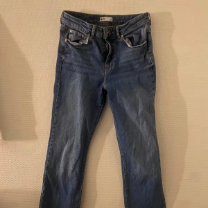 Blå jeans från Gina Tricot Perfect Jeans - Snygga blå jeans från Gina Tricot i storlek 38. Klassisk design med fem fickor och knappgylf. Perfekta för en avslappnad stil.