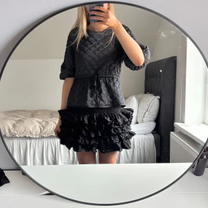 Festtopp - Snygg svart quiltad topp med trekvartsärm och knytband i midjan och i ryggen. Perfekt för en stilren look med det quiltade mönstret. Passar bra till både jeans och kjol. Storlek S från Kappahl. 