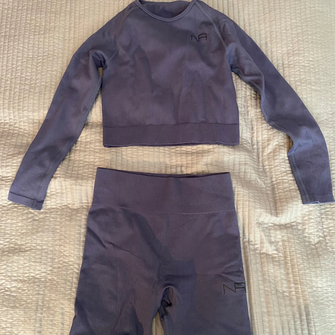 Lila ribbad träningströja och shorts från NA
