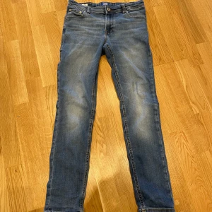 Blå jeans från Jack & Jones - Snygga blå jeans från Jack & Jones med en klassisk femficksdesign. De har en normal passform och är tillverkade i slitstarkt denim. Perfekta för en avslappnad stil.