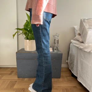 Blå bootcut jeans - Snygga blå bootcut jeans med klassisk femficksdesign. Perfekta för en avslappnad stil med en skön passform. Passar bra till både sneakers och klackar.
